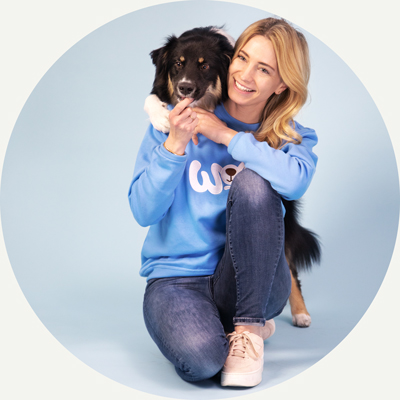 Katharina Miklauz with a border collie looking over her shoulder