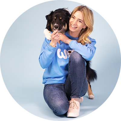 Katharina Miklauz avec un border collie qui regarde par-dessus son épaule